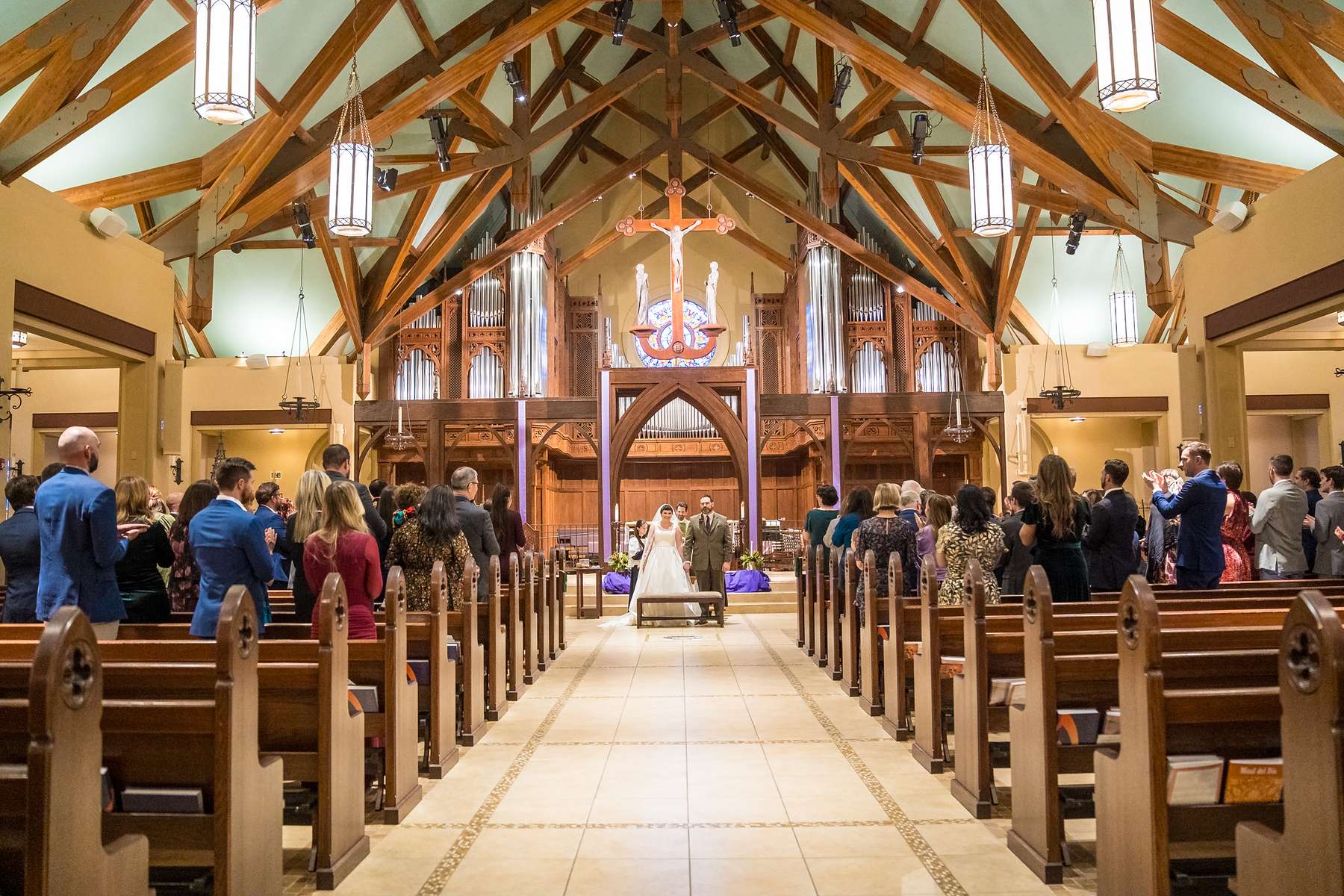 Couple walking back up the aisle after their wedding at Our Lady of the Assumption