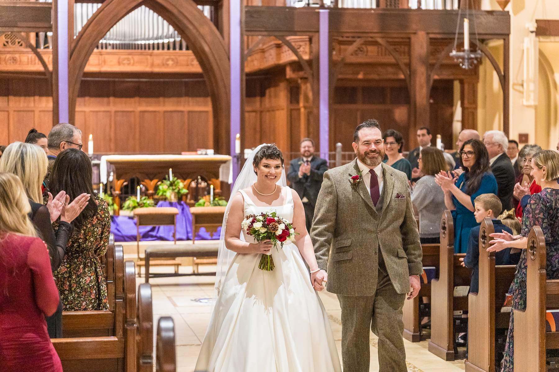 Guests celebrating as the couple leaves the sanctuary at Our Lady of the Assumption