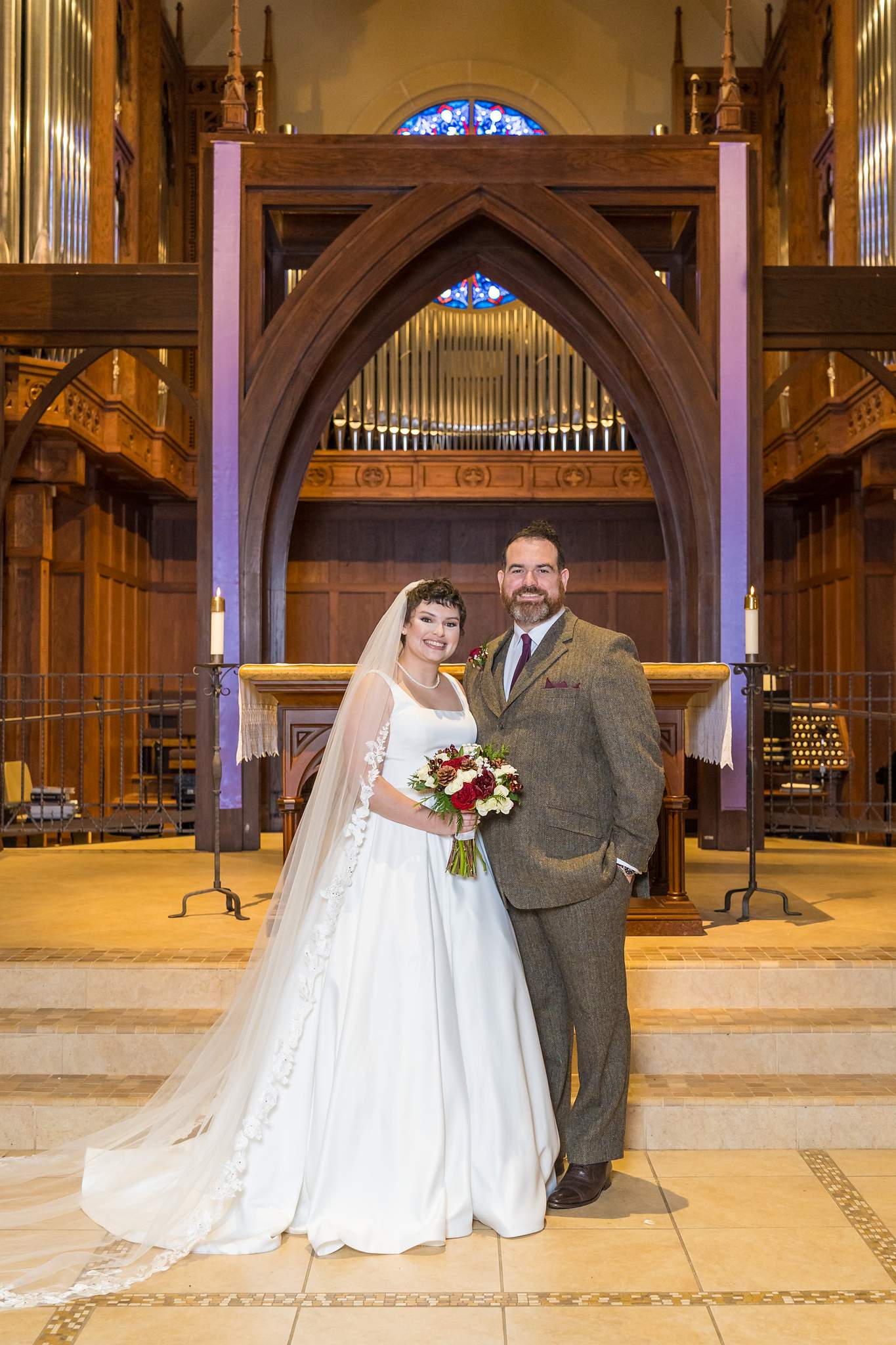 Couple portrait at the altar steps with the organ pipes behind