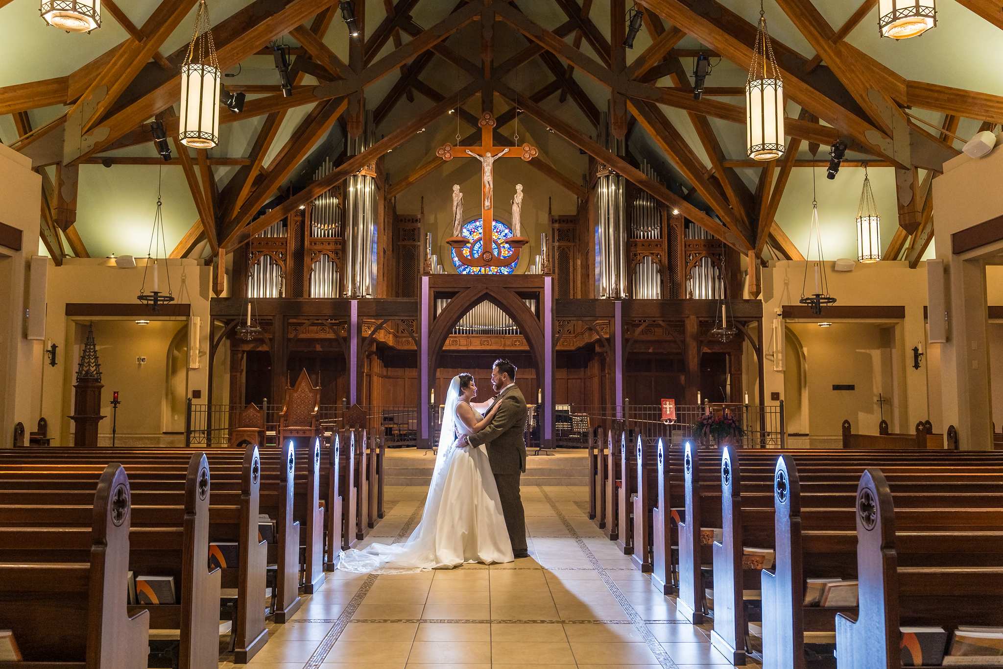 Couple kissing in the center aisle of Our Lady of the Assumption