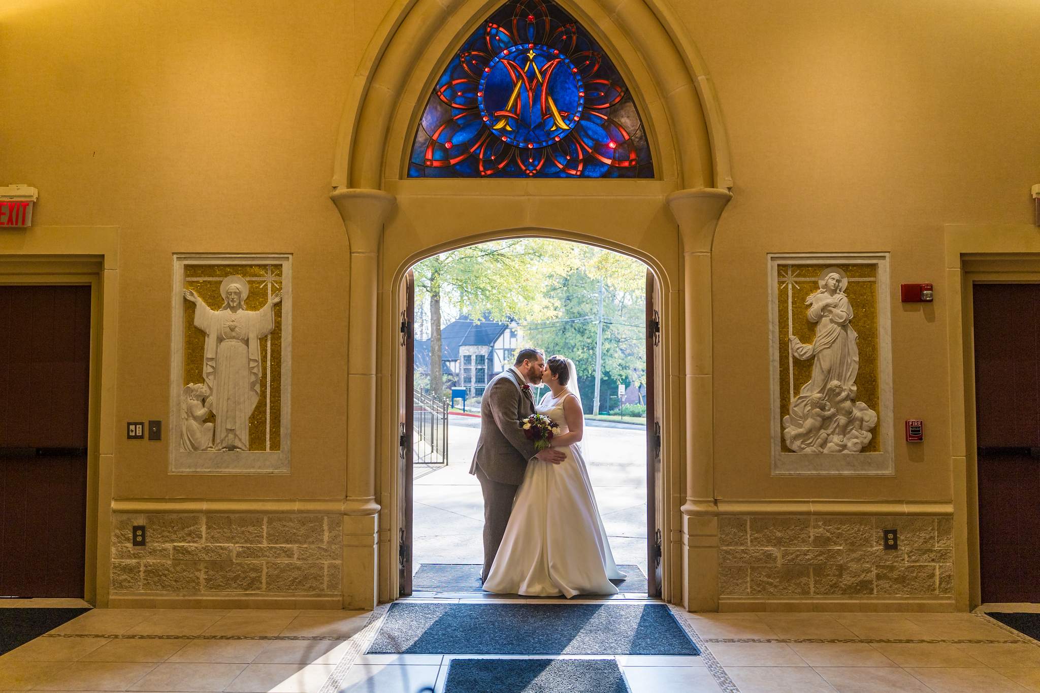 Couple framed by the entry doors at Our Lady of the Assumption Catholic Church