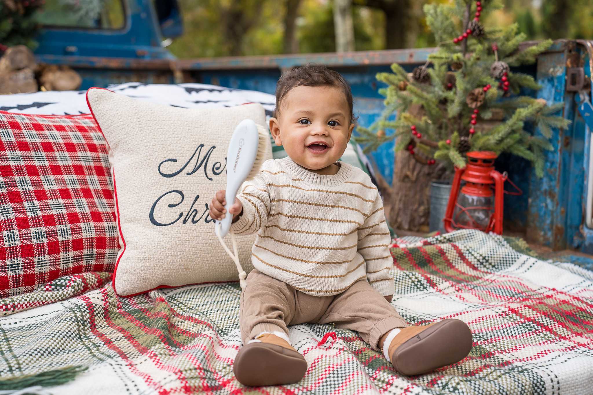 Baby in a striped sweater sitting in the back of the 1965 Blue Christmas Truck at Prospect Farms