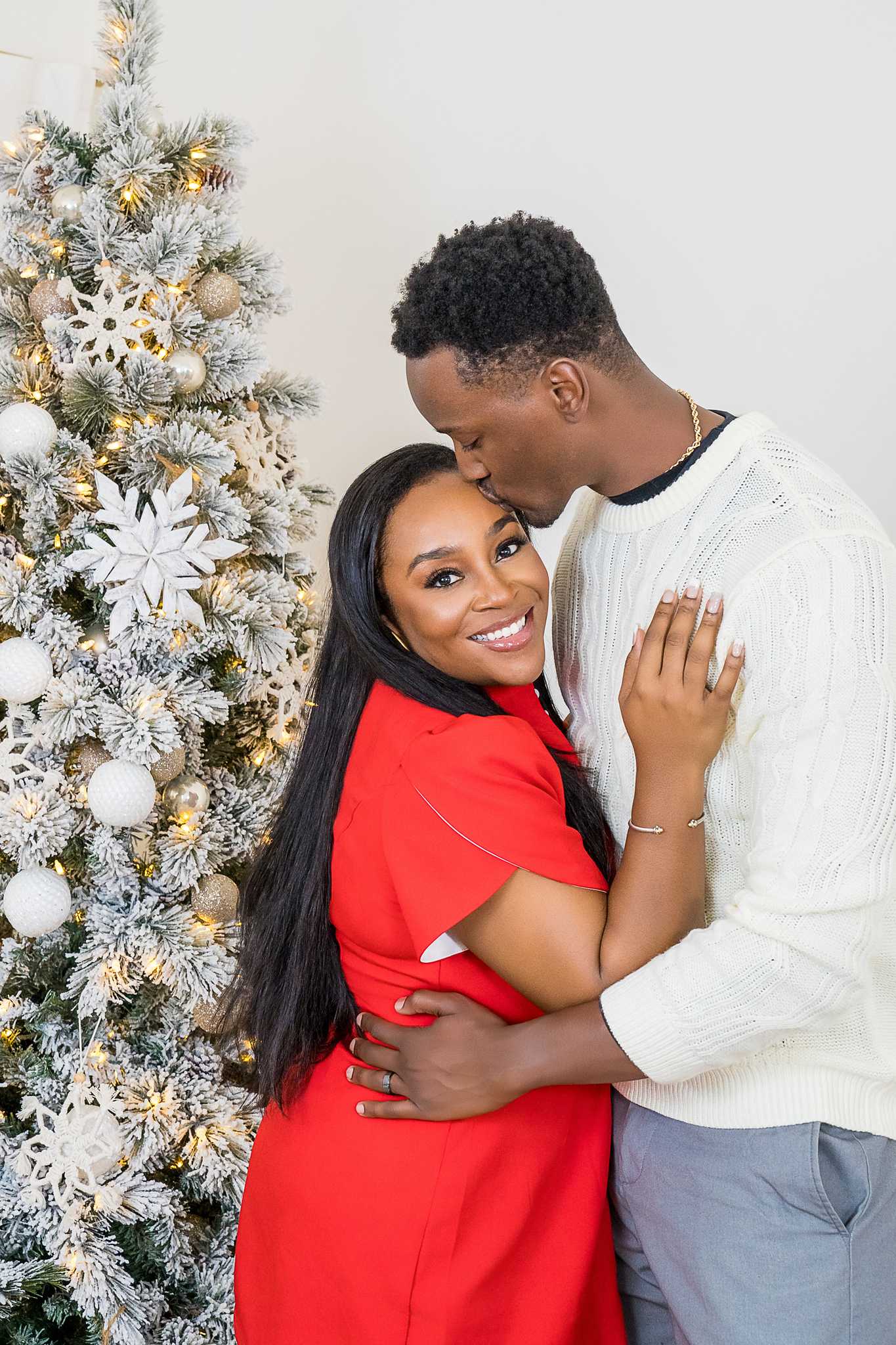 Couple embracing beside the white and gold Christmas tree in the Lounge at Prospect Farms