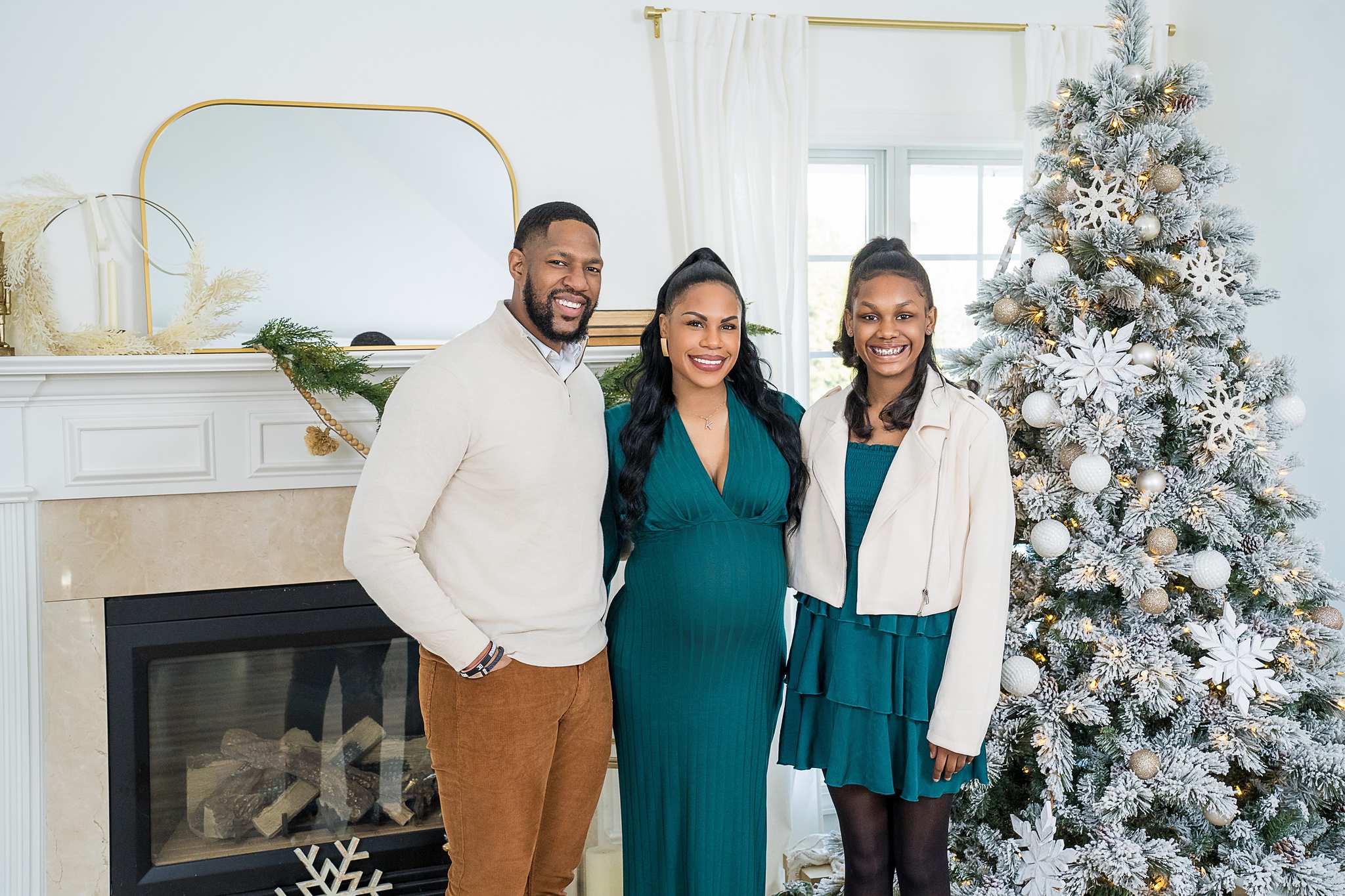 Family in camel, emerald and cream by the fireplace in the Lounge Christmas set