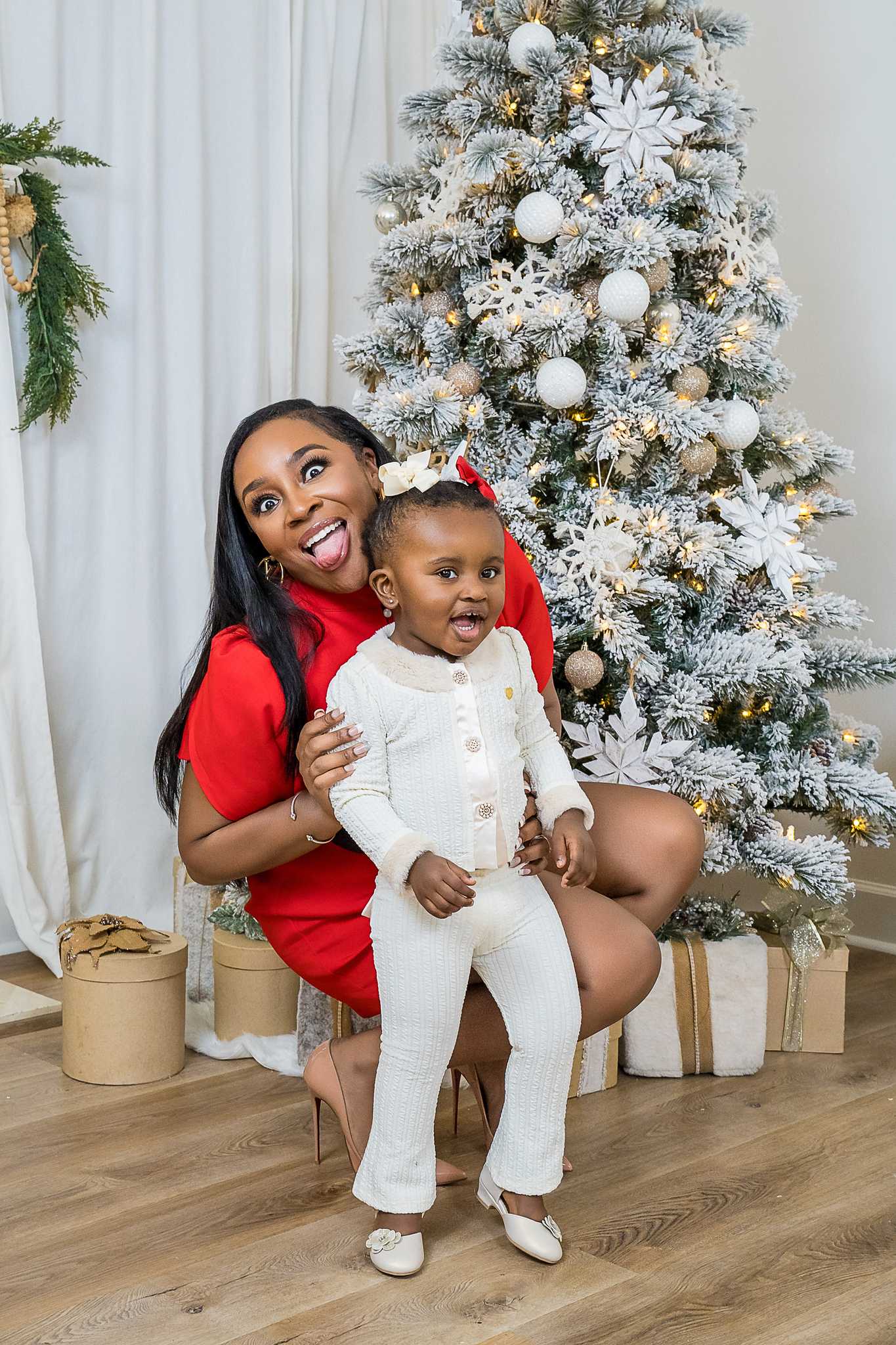 Mother in a red dress with her toddler beside the flocked tree in the Lounge Christmas set