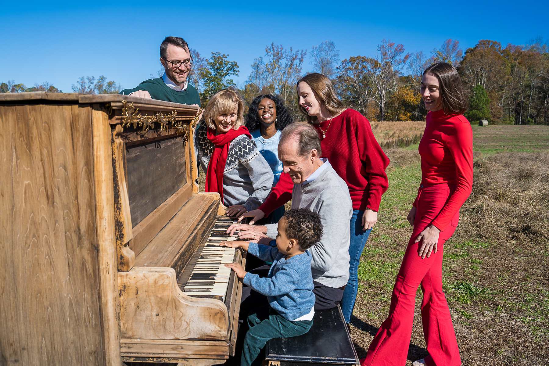 Family gathered around the vintage piano in the field at Prospect Farms