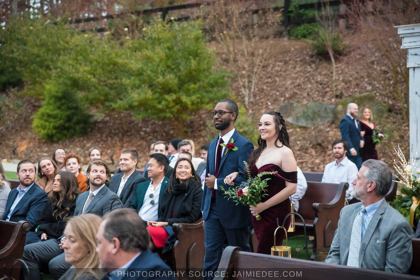 Rocky's Lake Estate Wedding Venue - Wedding ceremony - guests seated in outdoor pew benches with bridal party walking down the aisle
