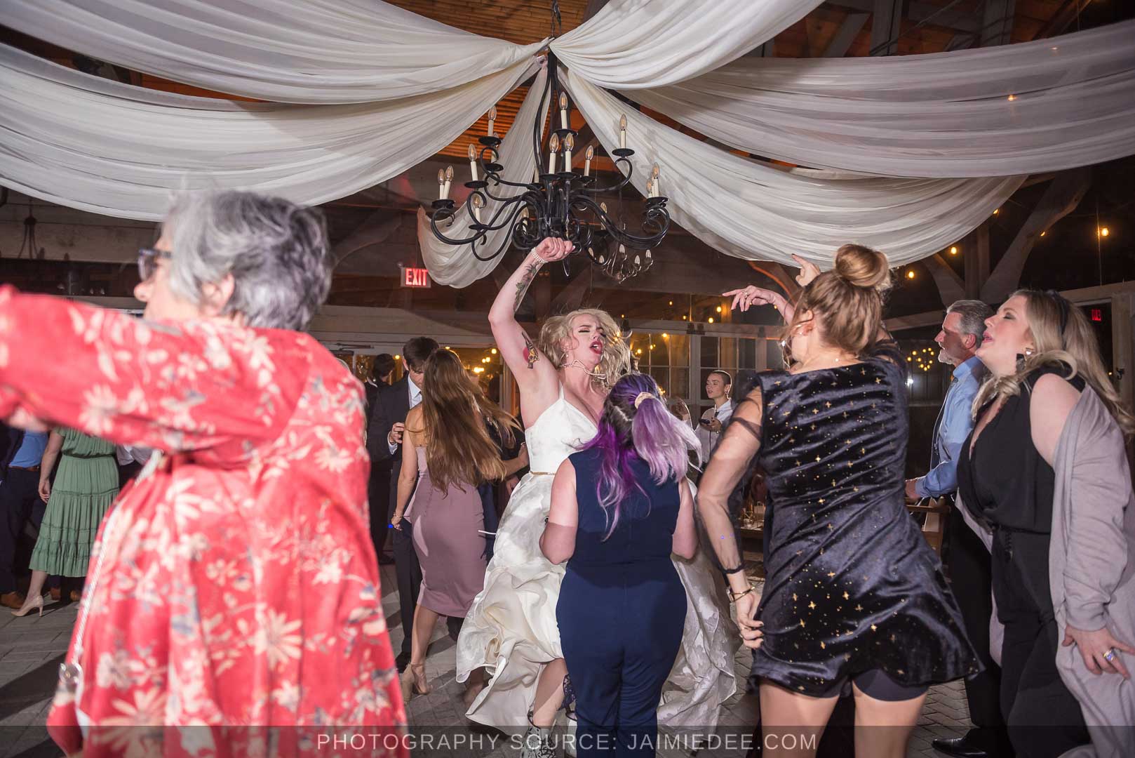 Rocky's Lake Estate Wedding Venue - reception - wedding guest dancing inside pavilion with ceiling drapes - bride dancing hard