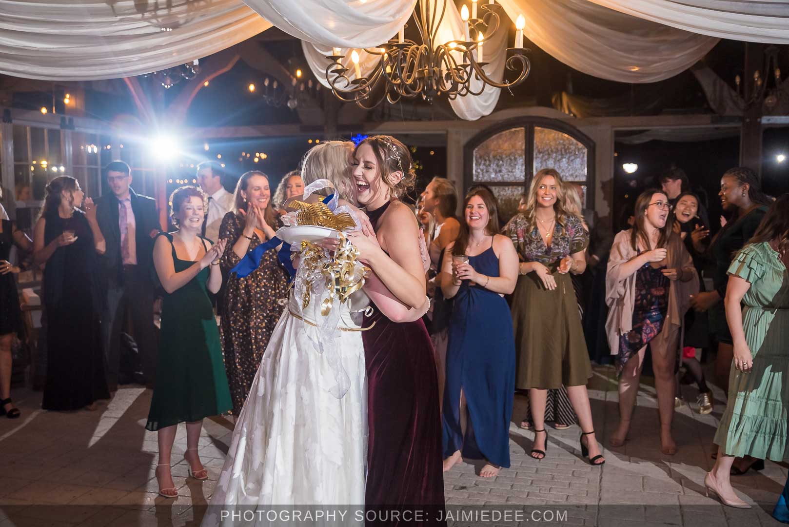 Rocky's Lake Estate Wedding Venue - reception - bride tosses bouquet inside pavilion with ceiling drapes - bouquet toss