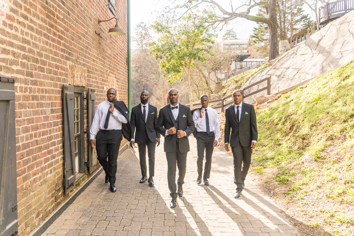 Groom and groomsmen by brick wall area for Roswell Mill Club wedding