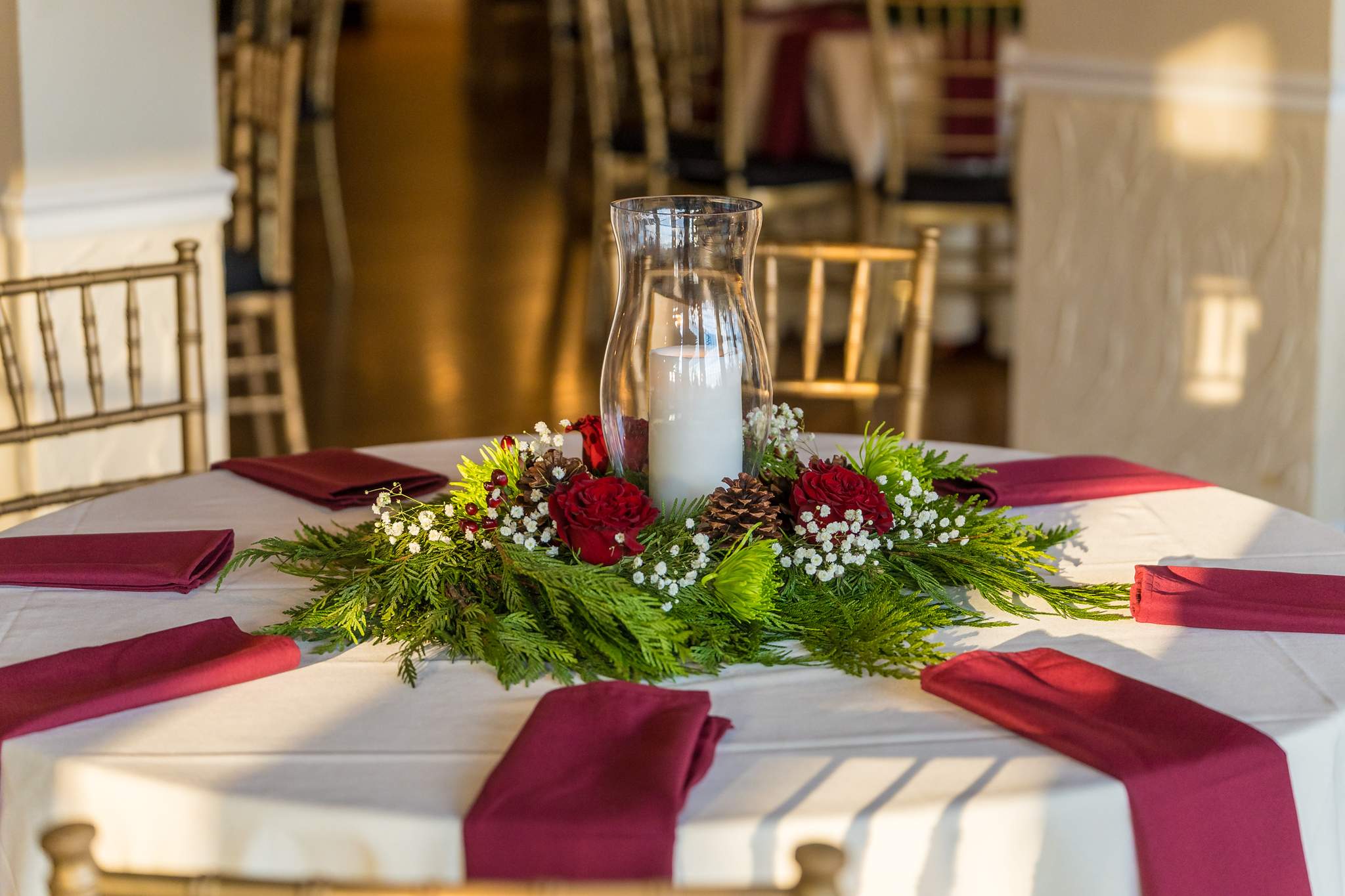 Christmas centerpiece with greenery and red napkins at Roswell Mill Club