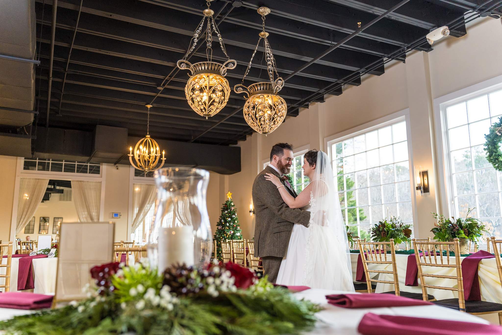 Couple sharing a moment behind a greenery centerpiece at Roswell Mill Club
