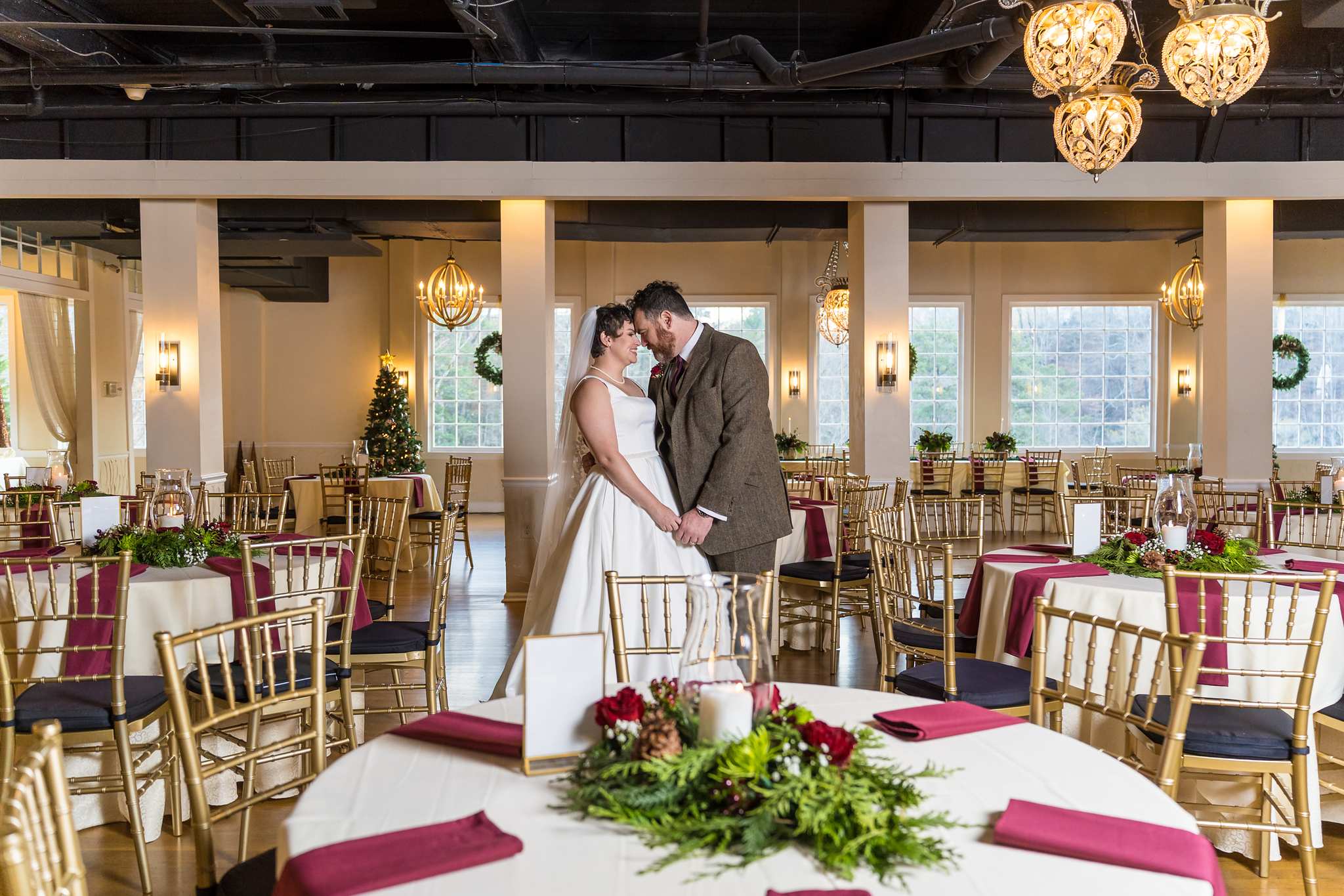 Couple in the reception room under gold chandeliers at Roswell Mill Club