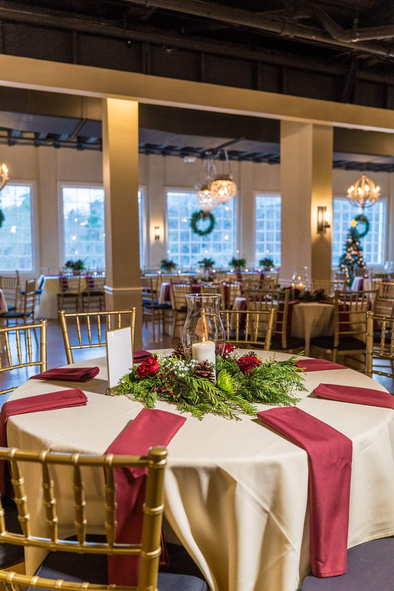 Reception table with gold chairs and burgundy napkins at Roswell Mill Club