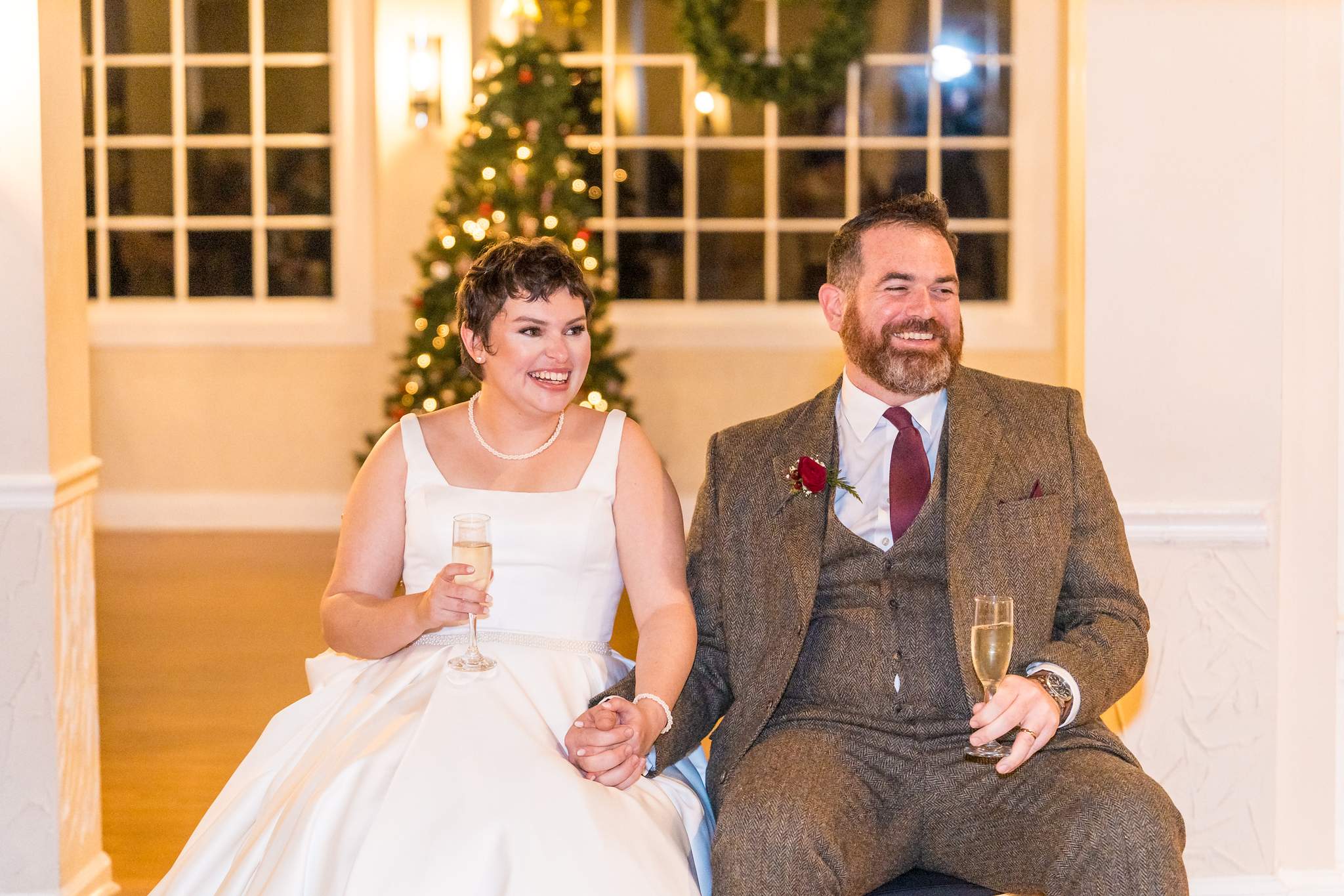 Couple laughing during toasts at a Roswell Mill Club Christmas wedding