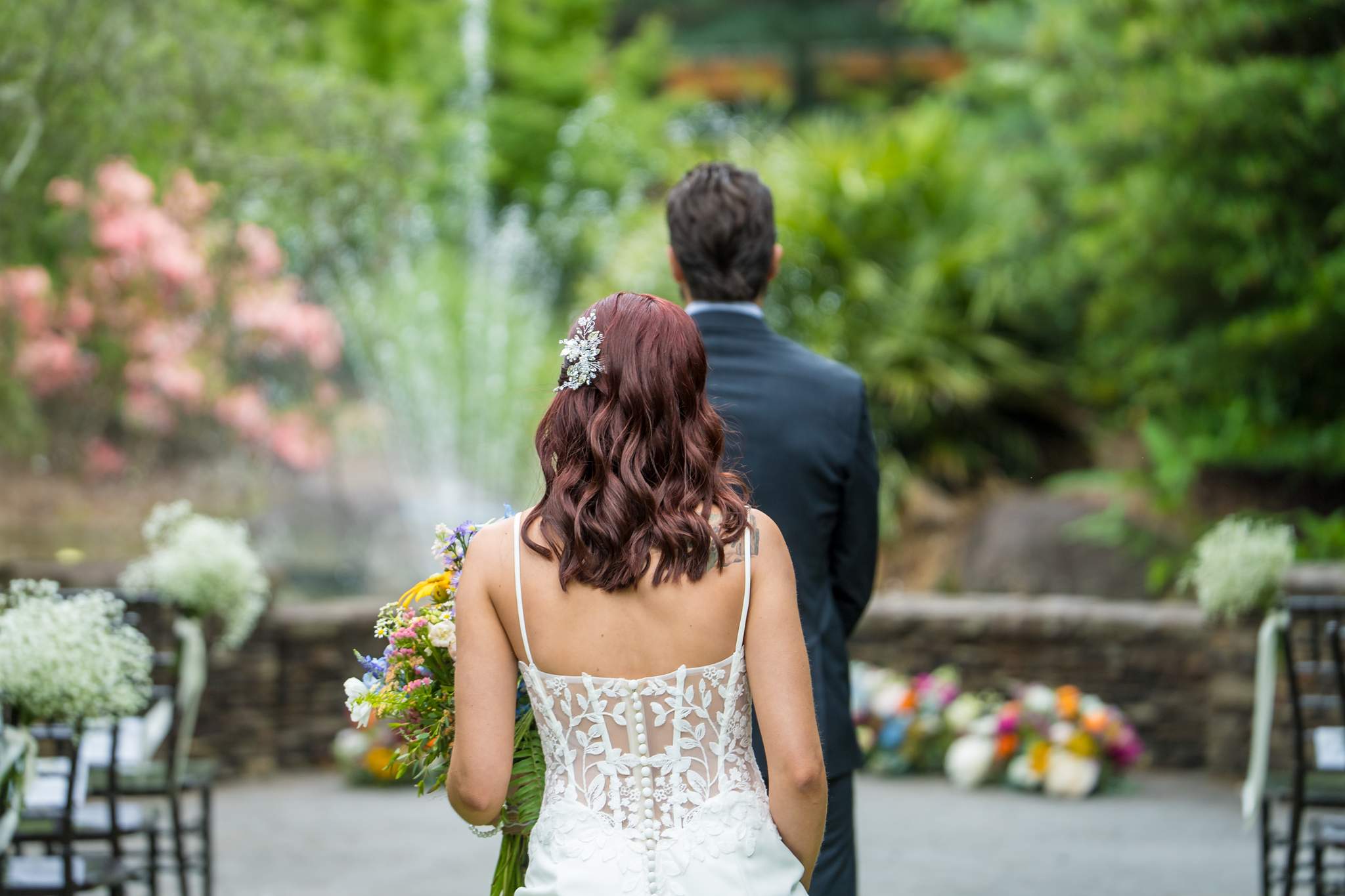 Bride approaching the groom by the fountain for a first look at Shiloh Gardens