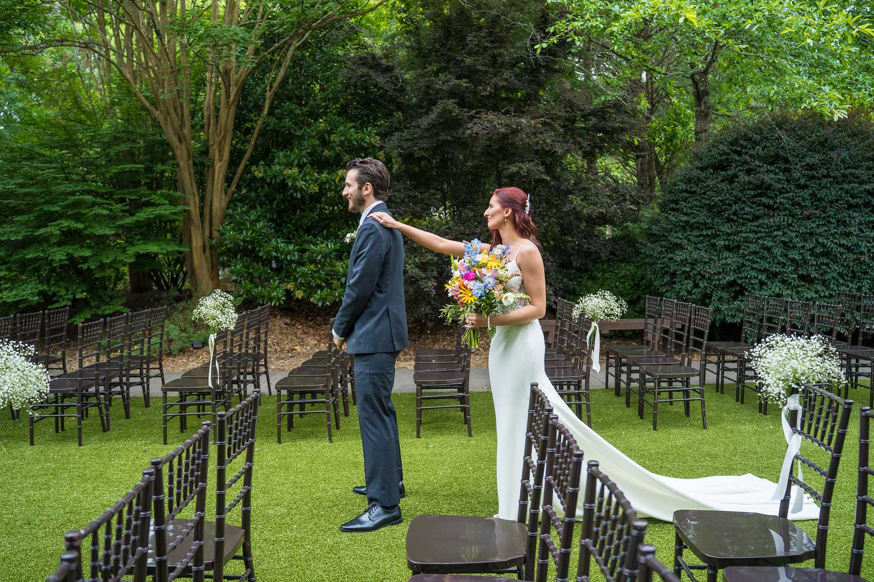 Groom turning to see the bride during a first look on the Shiloh Gardens ceremony lawn