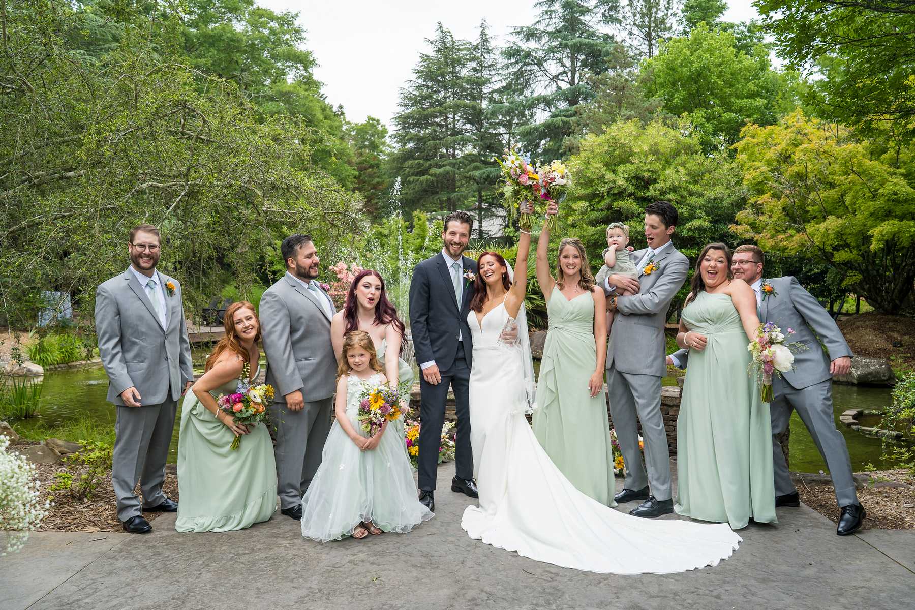 Wedding party celebrating with the couple in the gardens at Shiloh Gardens