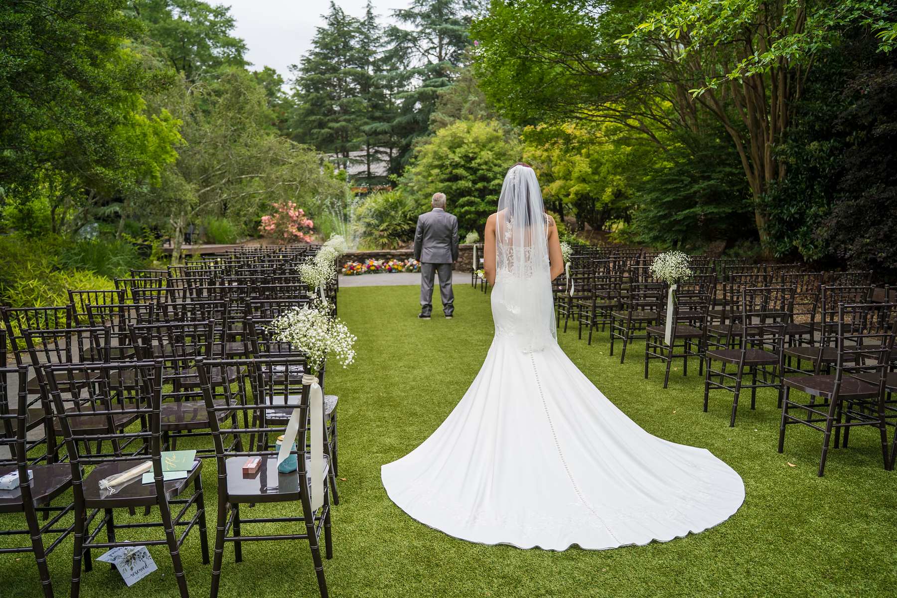 Bride walking down the grass aisle at Shiloh Gardens before the ceremony