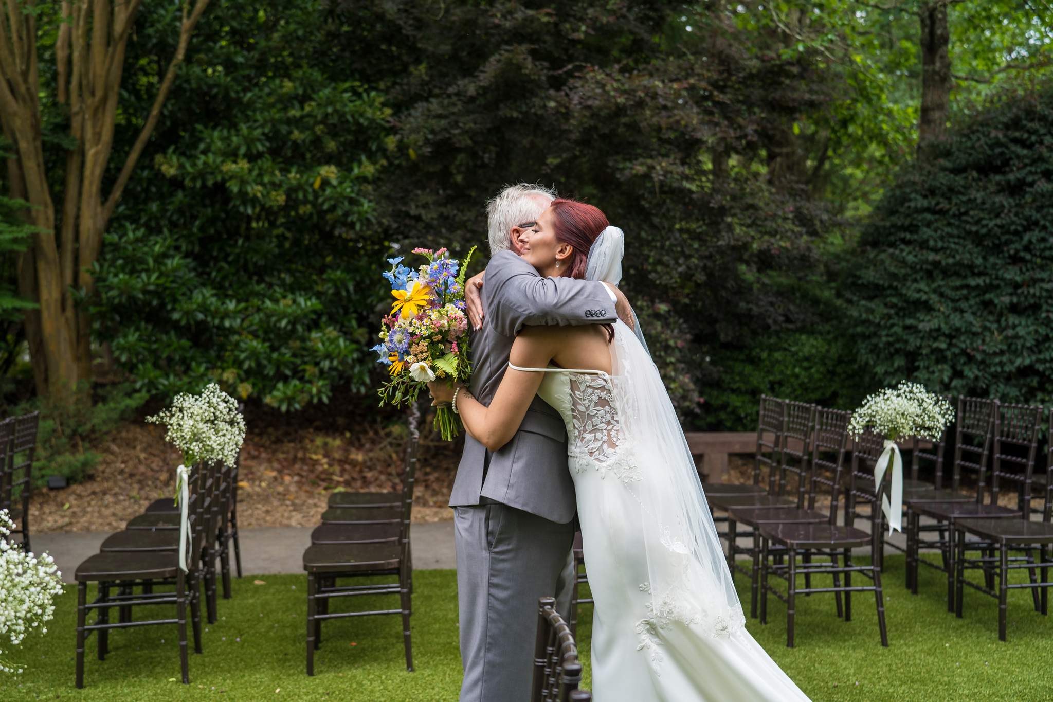 Bride sharing a hug with a family member on the ceremony lawn at Shiloh Gardens