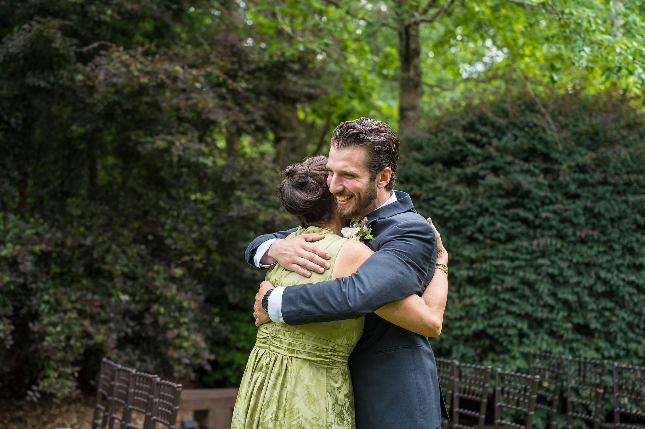 Groom hugging a family member before the ceremony at Shiloh Gardens