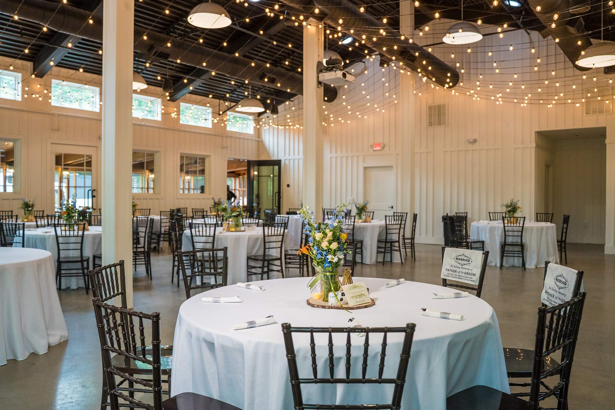 Reception tables under string lights in the Giaquinto Event Center at Shiloh Gardens