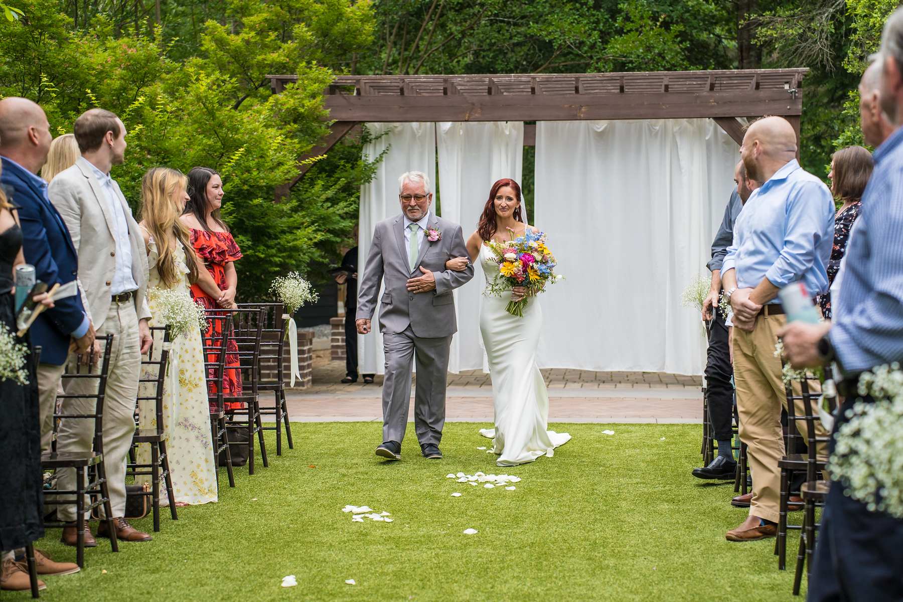 Bride walking down the aisle on the ceremony lawn at Shiloh Gardens