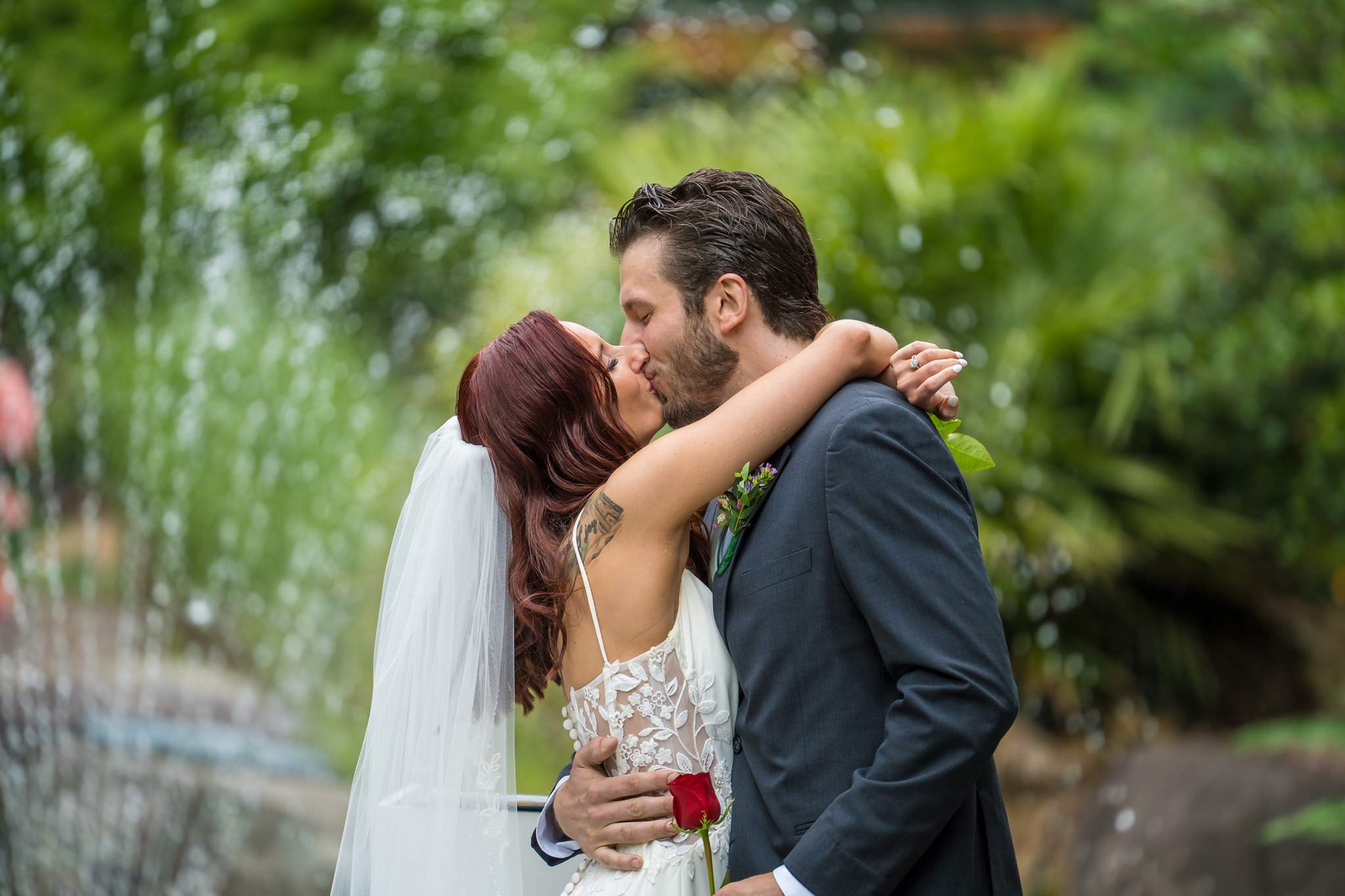 Couple kissing in front of the fountain at Shiloh Gardens