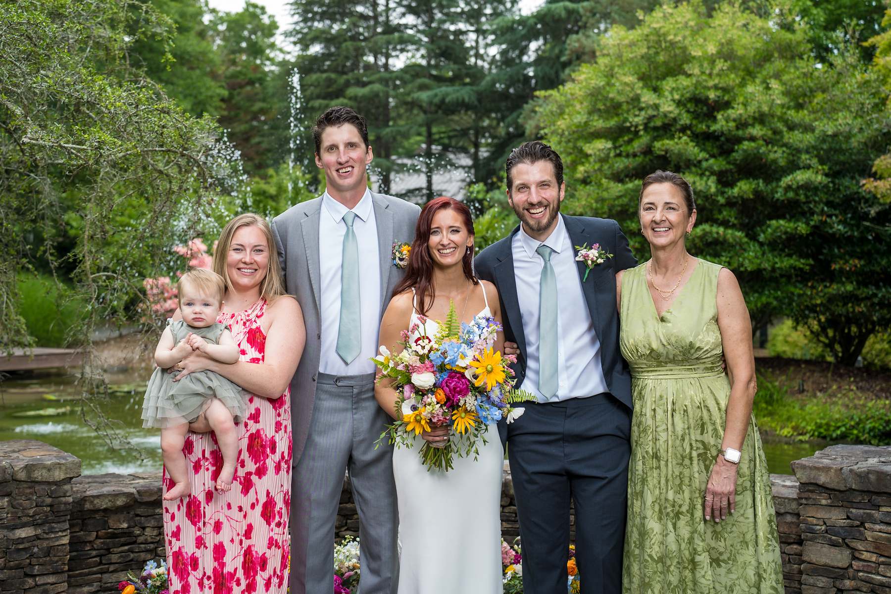 Family portrait with the couple beside the pond at Shiloh Gardens