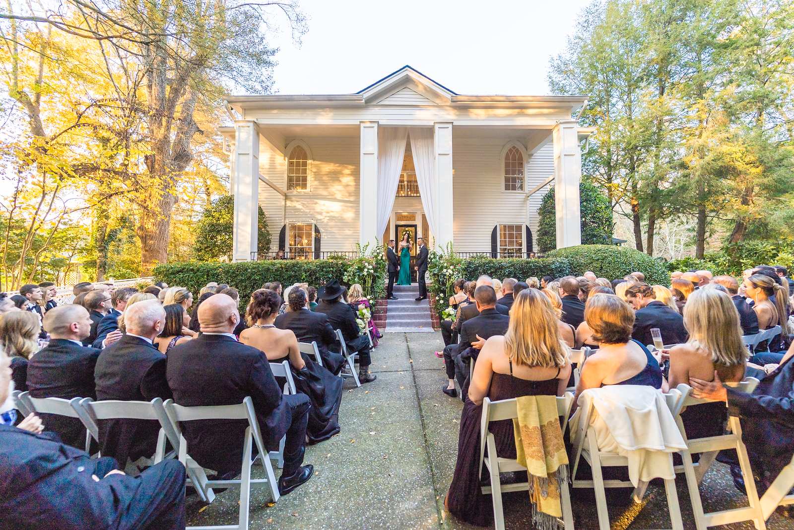 Outdoor wedding ceremony in front of the historic white house at The Cedars in Acworth