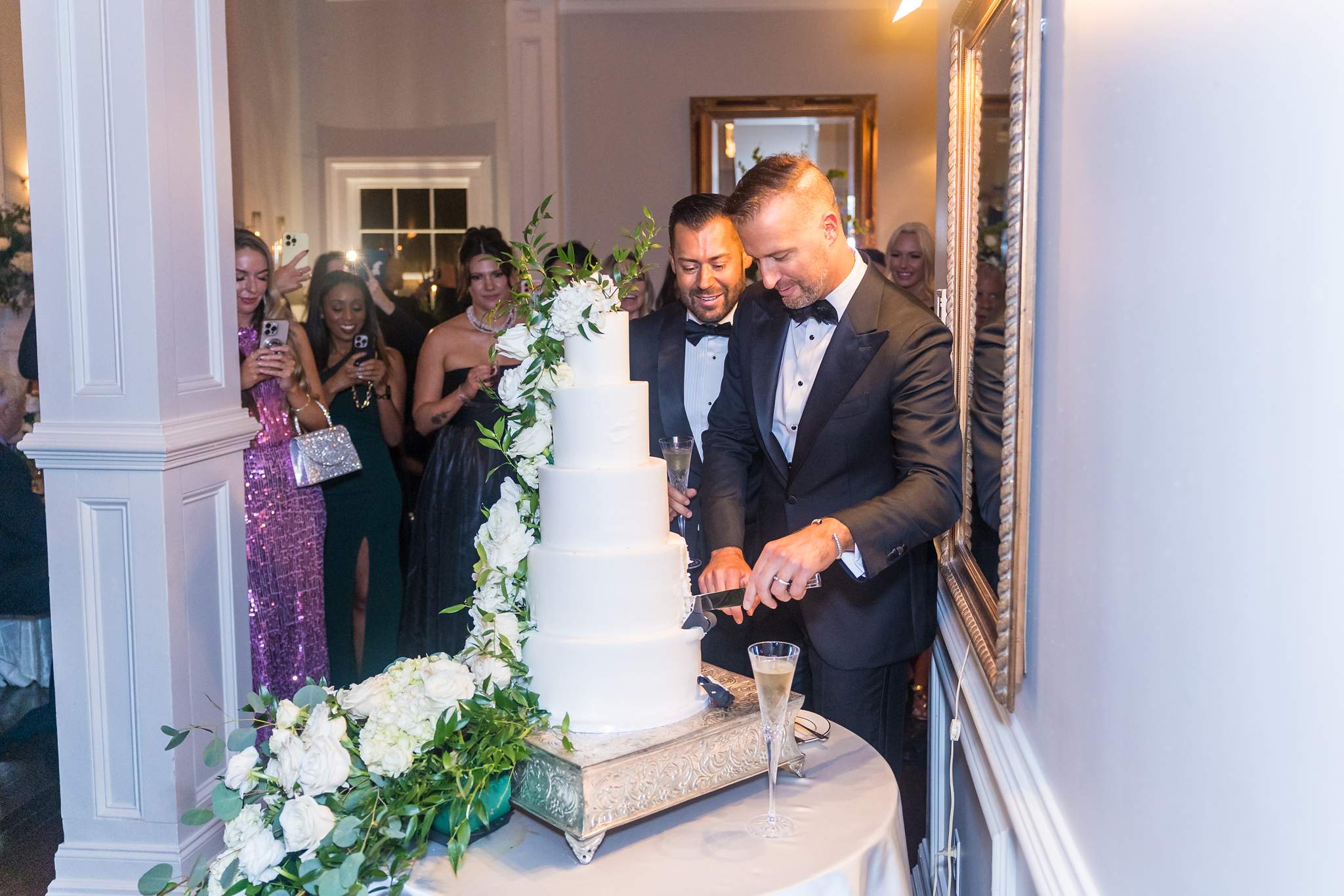Couple cutting a white floral wedding cake at The Cedars in Acworth