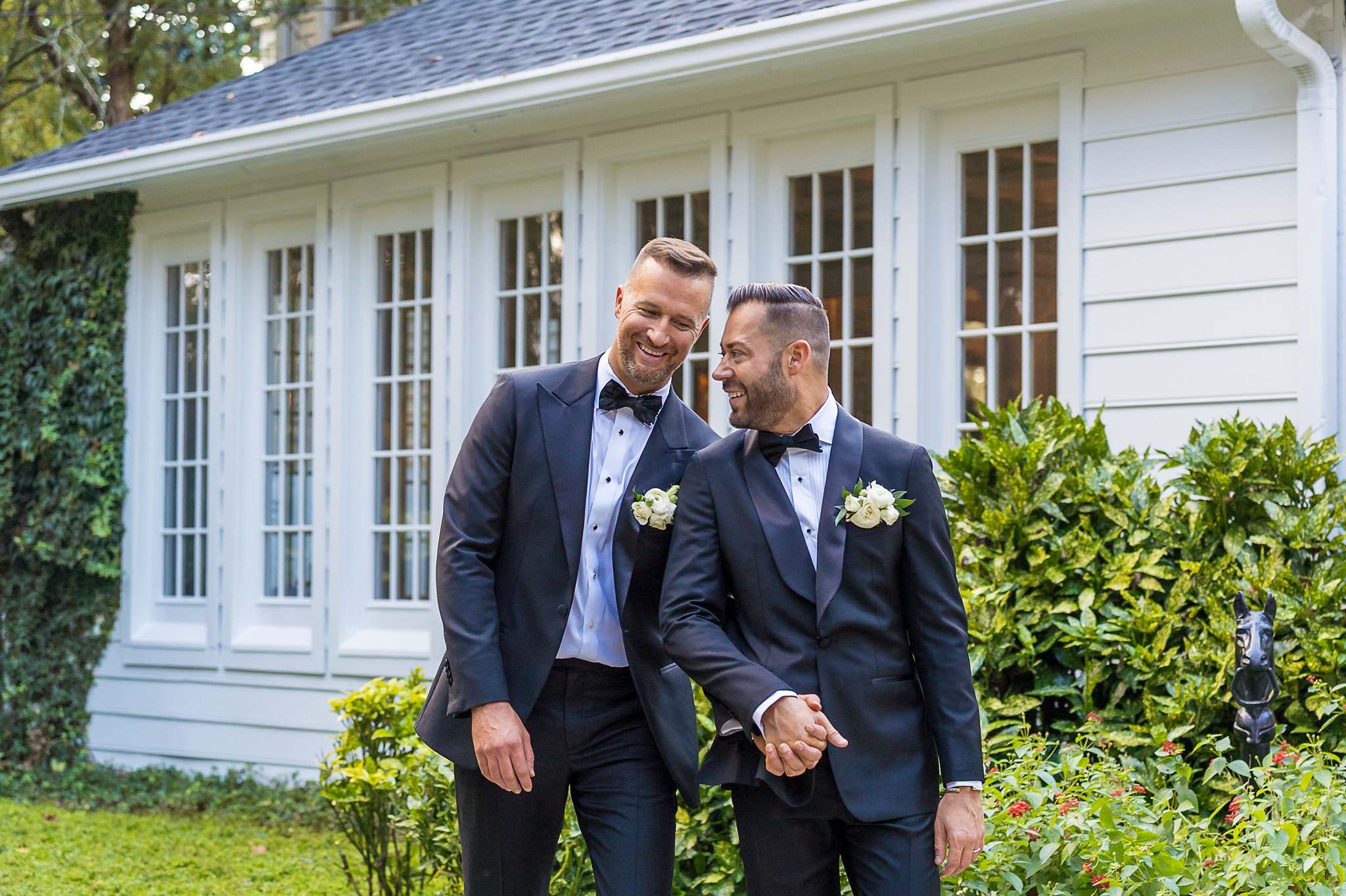 Couple laughing beside the white historic home at The Cedars in Acworth