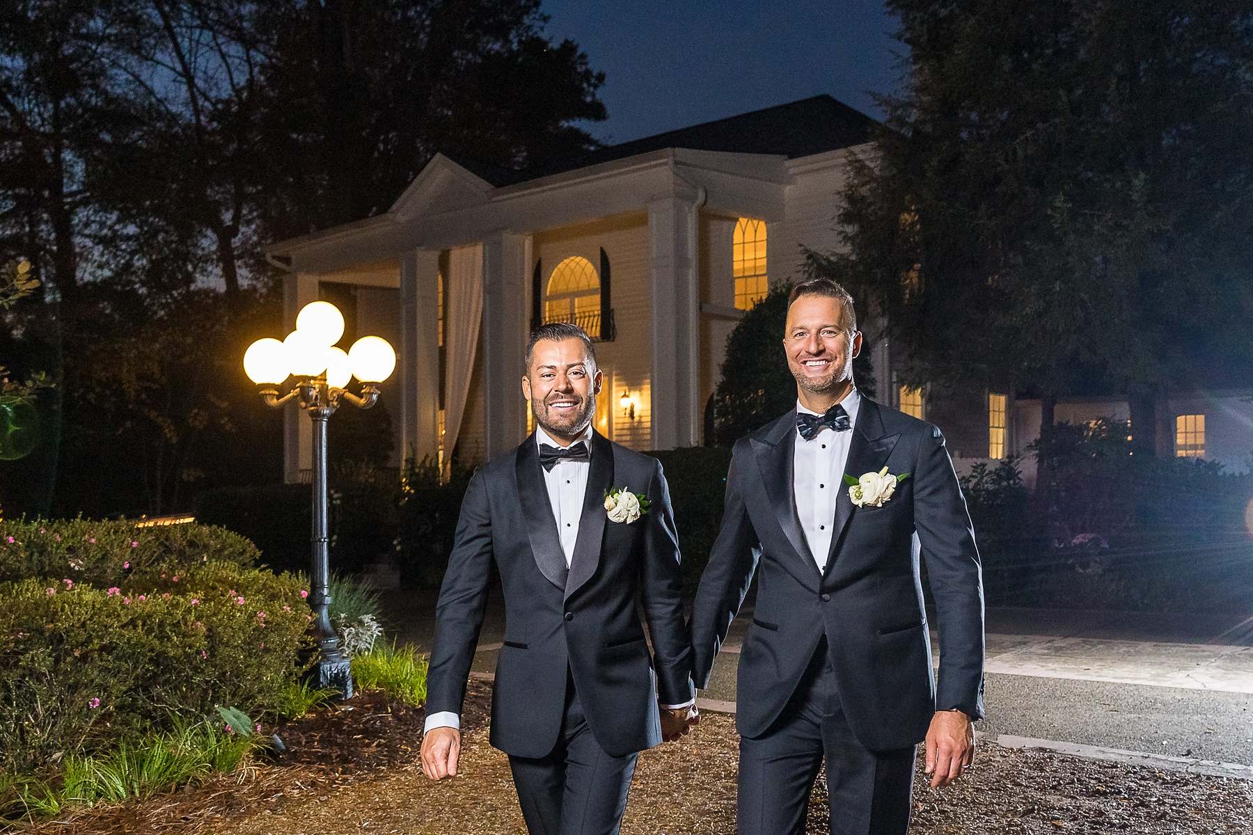 Couple walking at dusk in front of the lit house at The Cedars in Acworth