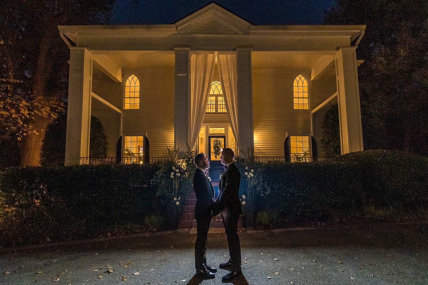 Night portrait of the couple with the glowing house behind them at The Cedars in Acworth
