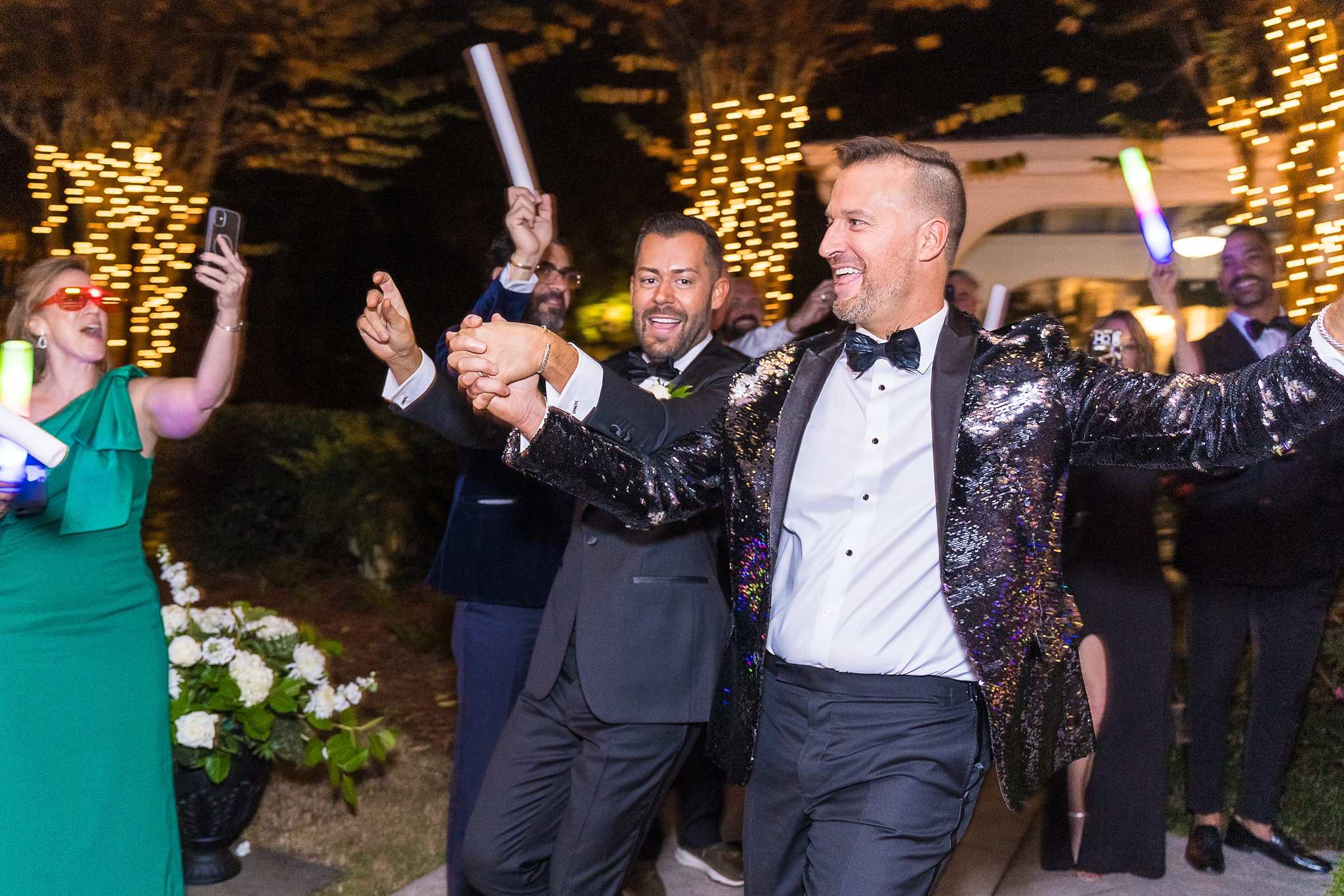 Couple celebrating as guests cheer at the reception entrance