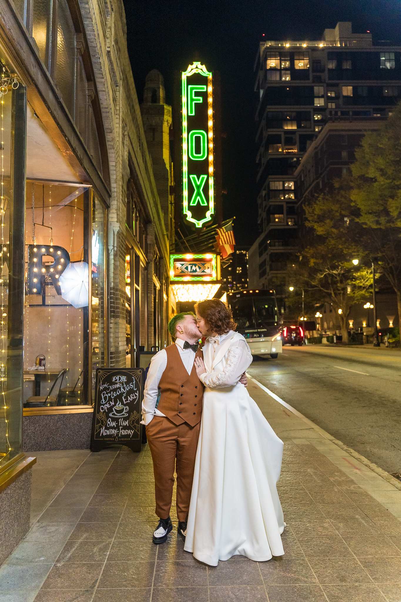Couple under the lit Fox Theatre sign at night