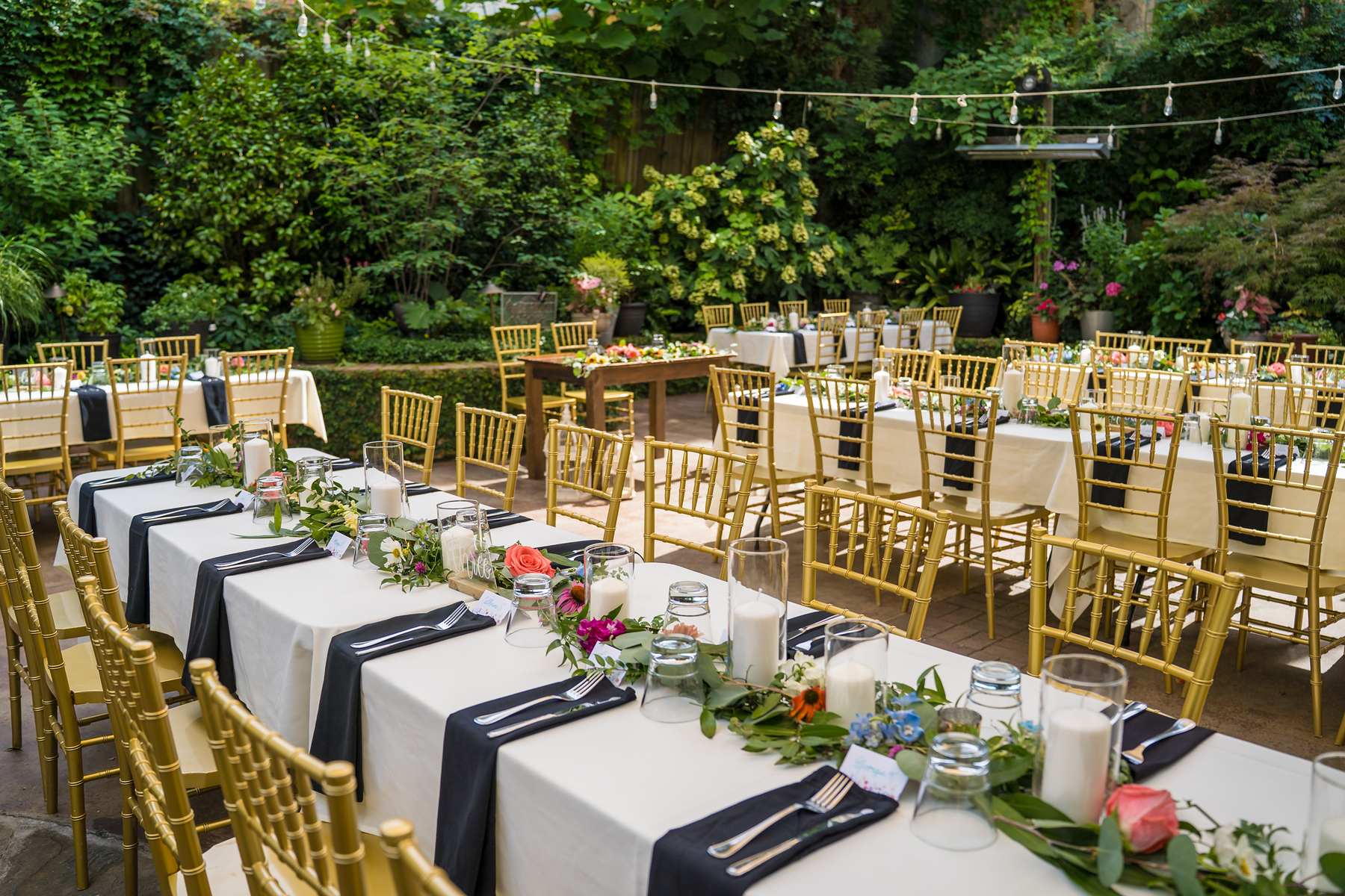 Reception tables set in the lush garden at Wahoo! Grill in Decatur