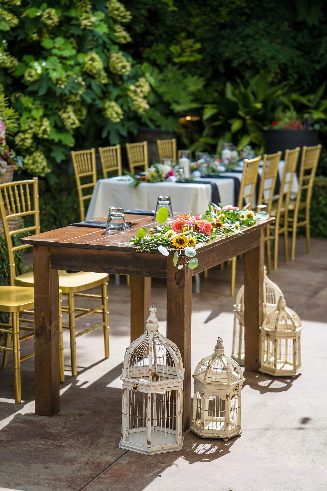 Garden table with flowers and lanterns at a Wahoo! Grill wedding