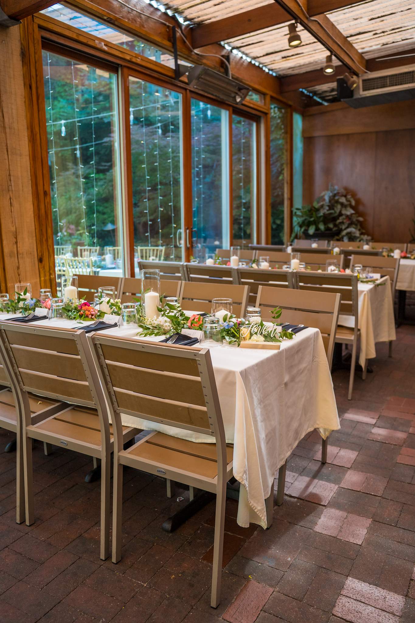 Glass-walled dining room set for a wedding reception at Wahoo! Grill