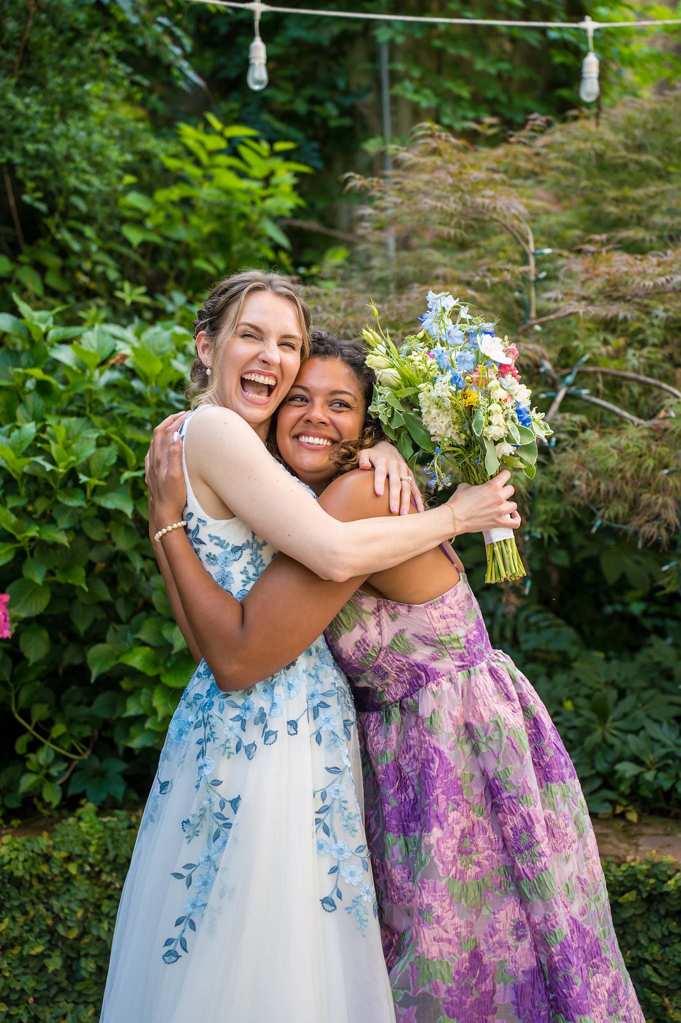 Bride hugging a friend in the garden at Wahoo! Grill