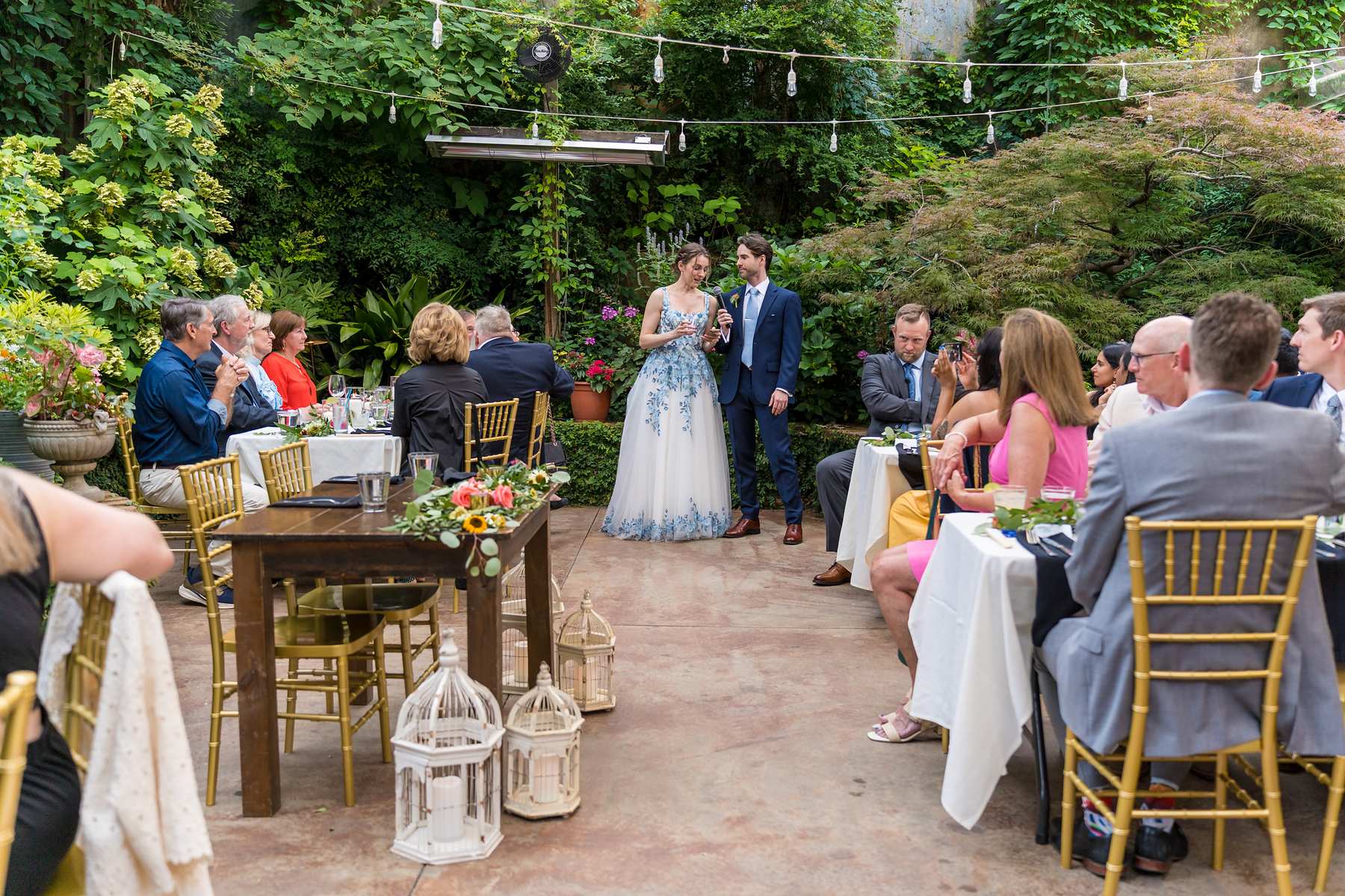 Guests gathered at tables in the garden at a Wahoo! Grill wedding