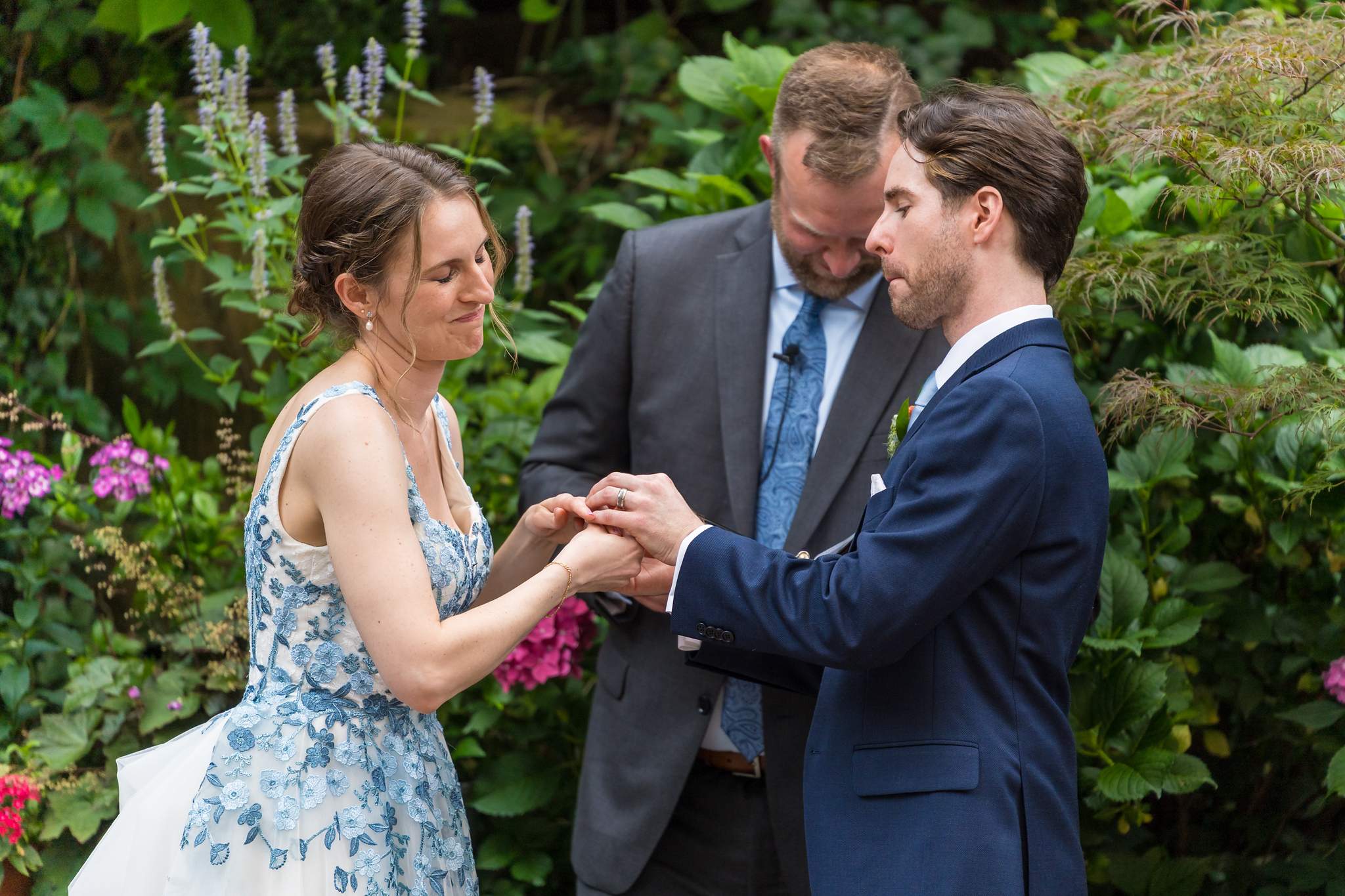 Couple holding hands with a family member during a garden celebration at Wahoo! Grill