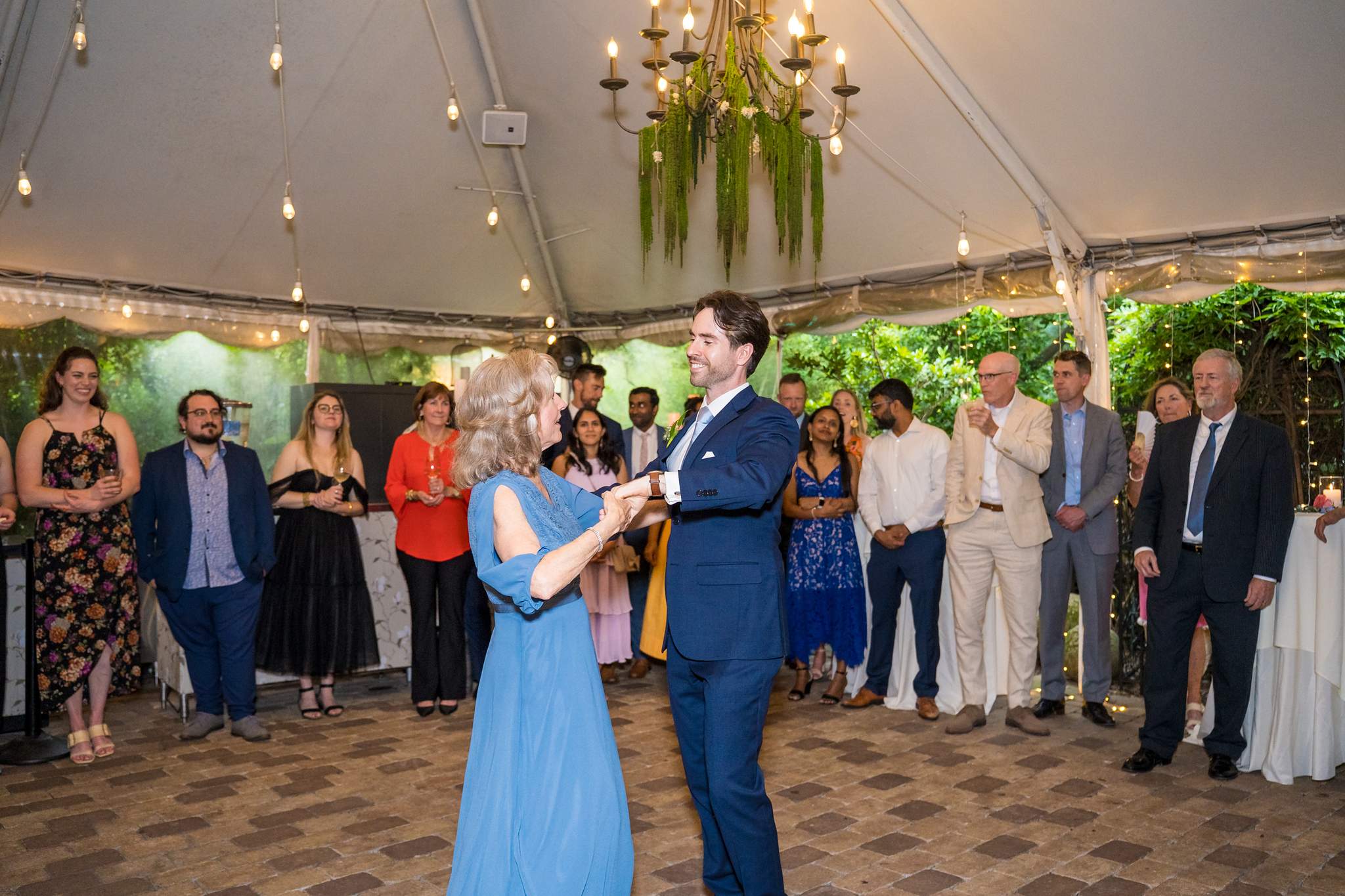 Groom dancing with a family member under the tent at Wahoo! Grill