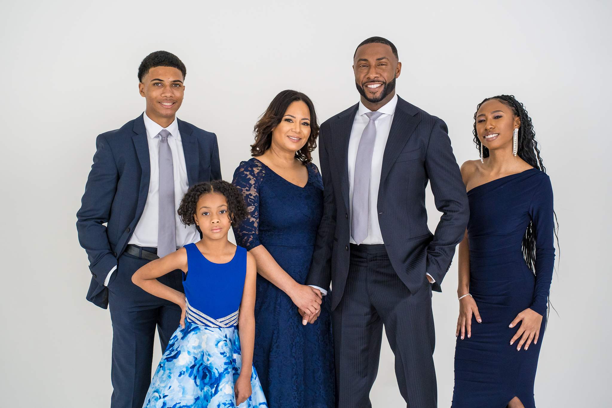 Family in navy suits and navy dresses with a girl in royal blue florals at White Wall Studio